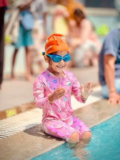 A series of candid shots showing a young swimmer's journey of getting comfortable at the pool's edge. From happy claps to playful splashes, it's all part of the learning process.