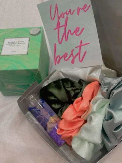 Even a small hamper can make a big impact. This cute box contains a scented candle, a set of colorful satin scrunchies, a small vial of bath salts, and a "You're the best" card.