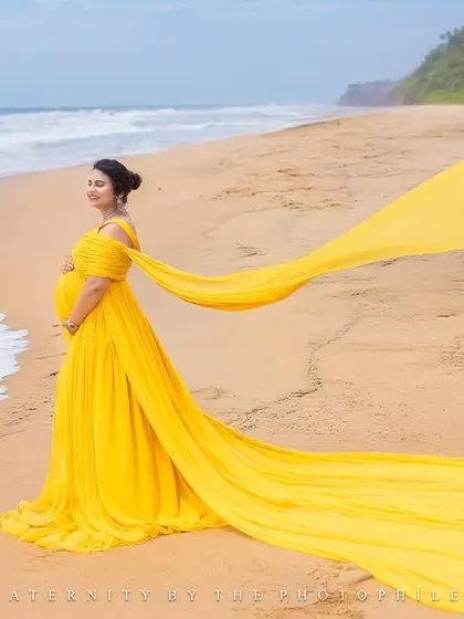 A splash of sunshine in this vibrant yellow gown. The long trail creates a beautiful line against the sand and waves, making for a joyful and visually striking portrait at Varkala beach.