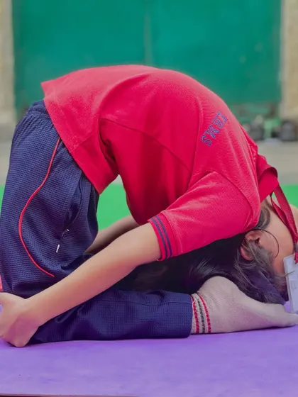 A reclining split pose, showing the flexibility that can be developed at a young age with proper guidance.