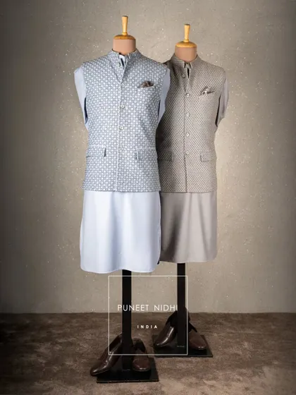 My favorite Pathani suit collection, shown here in light blue and grey. The geometric print Nehru jacket adds a touch of modern flair to the traditional silhouette.