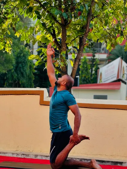 A member demonstrates a deep stretch in a modified camel pose, showcasing the flexibility gained through consistent practice.