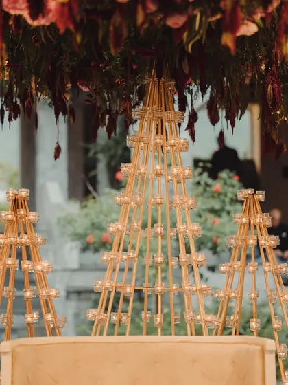 A close-up of the candle-lit pyramids that formed the backdrop for a traditional Bunt ceremony. These custom structures, combined with deep red floral arrangements, created a warm, glowing ambiance.