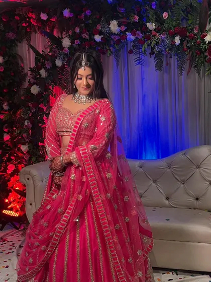 A close-up of the bride at the ring ceremony, with the detailed floral decor visible in the background.