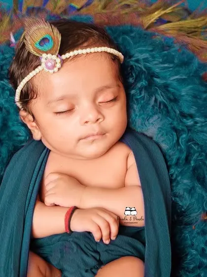 Capturing the divine innocence of a sleeping newborn. This shot from our Janmashtami series uses soft fabrics and a peacock feather headband to complete the 'natkhat Nandlal' look.