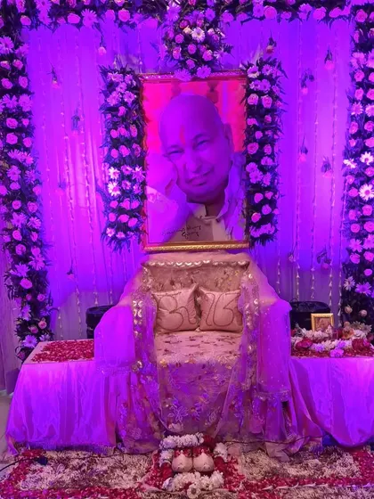 This image shows how lighting can transform a space. It is the same satsang decoration as a previous photo, but illuminated with purple light to create a different, more meditative mood for an evening event.