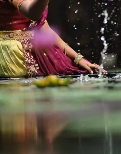 A close-up detail from the photoshoot, showing the beautiful half-saree and the reflection in the water.