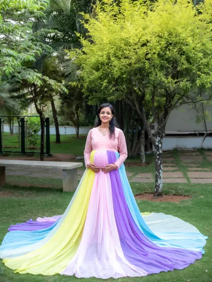 A beautiful outdoor portrait featuring our popular rainbow pastel gown. The colors of the dress look so soft and pretty against the green lawn and trees.