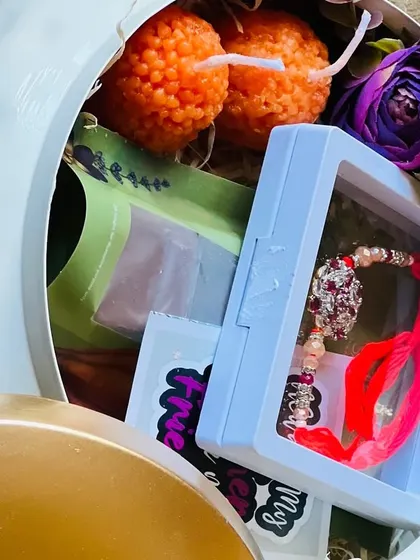 A close-up of the contents inside the ceramic Rakhi pot, including a beautiful jeweled rakhi.