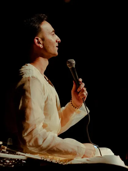 Speaking to the audience during an intimate show. I engage with guests, sharing the stories behind the music and the principles of 'Sitar for Mental Health'.