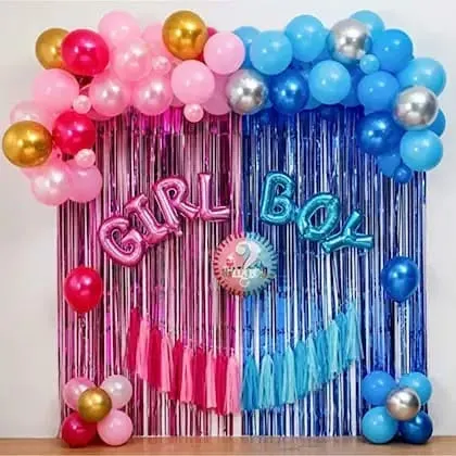 A classic gender reveal or baby shower backdrop. The decor uses a split curtain of pink and blue foil, with matching balloon arches and 'GIRL' and 'BOY' foil letters.