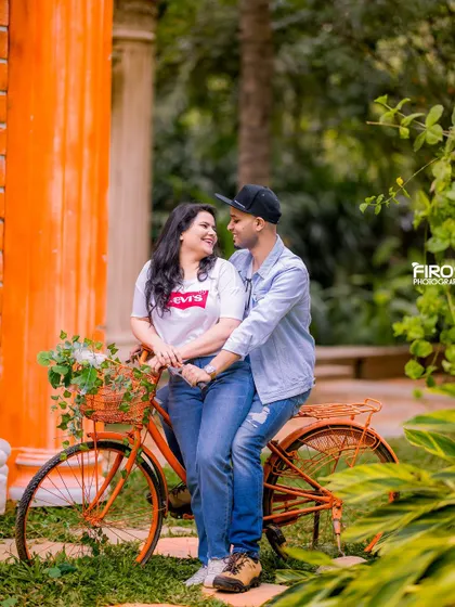 A happy, relaxed pose on a bicycle. The couple's casual outfits and the colorful background create a fun and vibrant pre-wedding photo.