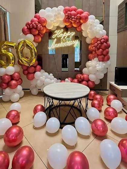 For a milestone 50th anniversary, I created this elegant indoor balloon circle arch in chrome red and white. The design is complemented by a 'Happy Anniversary' neon sign and large gold foil '50' balloons to mark the special occasion.
