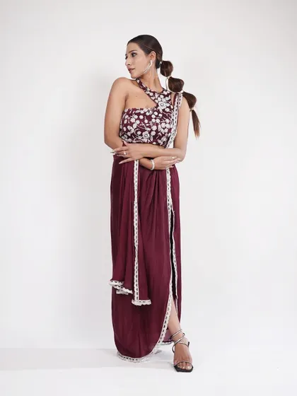 Another view of the wine-colored draped outfit. The unique silhouette and rich color make it a standout piece for any celebration.