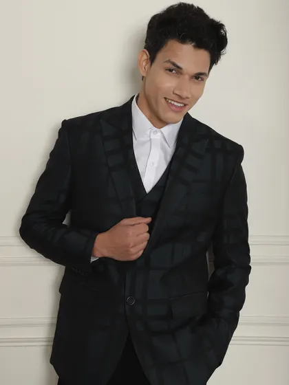 A smiling model in our black checkered suit, proving that formal wear can be both stylish and comfortable.