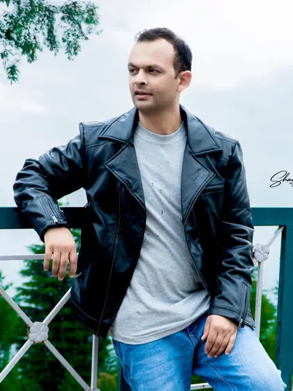A handsome portrait of the groom-to-be in his leather jacket. The natural background and soft light create a classic, masculine look.