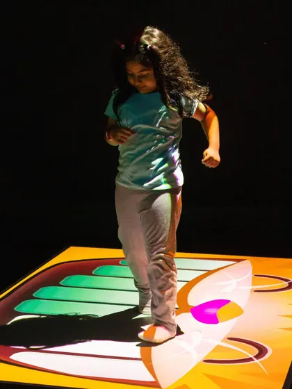 Hopping on a virtual piano projected on the floor. It's a fun way to make music with your feet!