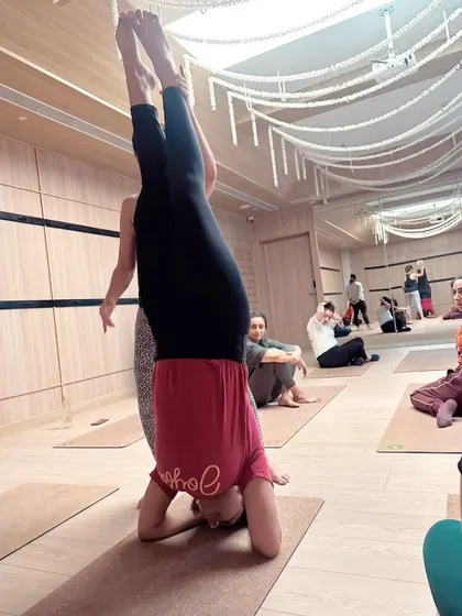 A view from the side during a headstand workshop. Notice the other participants resting or observing; every part of the process, including rest, is a part of learning.