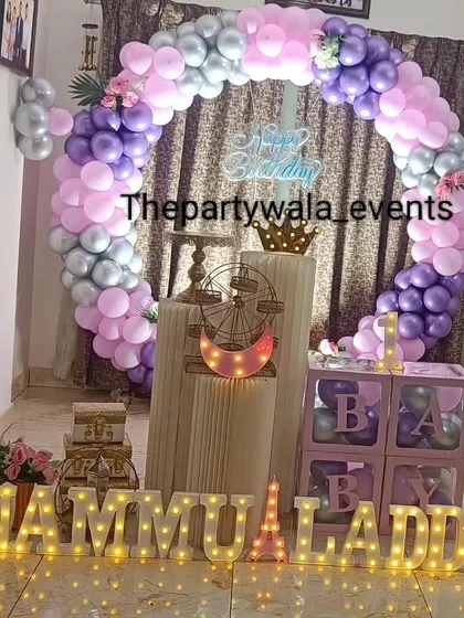A lovely ring decoration with purple, pink, and silver balloons, complete with 'BABY' blocks and light-up letters.