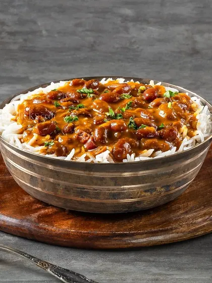 A comforting bowl of Rajma Chawal, a staple in North Indian homes, served in a traditional brass bowl.