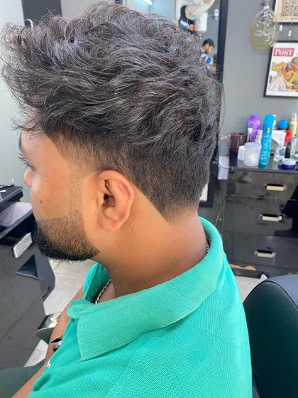 This style combines a messy, textured top with a sharp, faded V-shape at the nape. It’s a great example of how I can balance a relaxed style with the clean lines of a precision haircut.