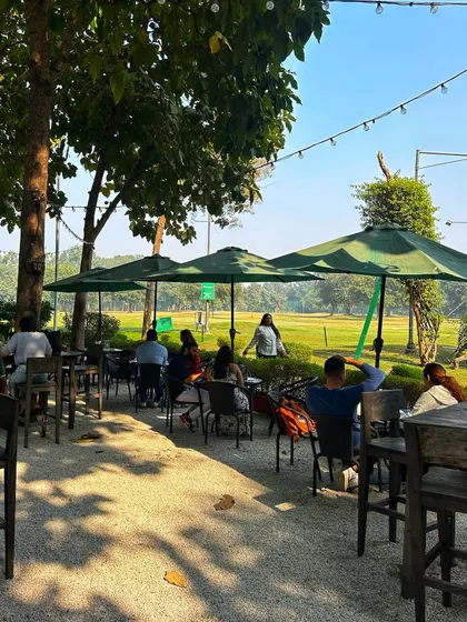 Guests relaxing at the cafe, with golf bags nearby. It's the perfect 19th hole to discuss your game.