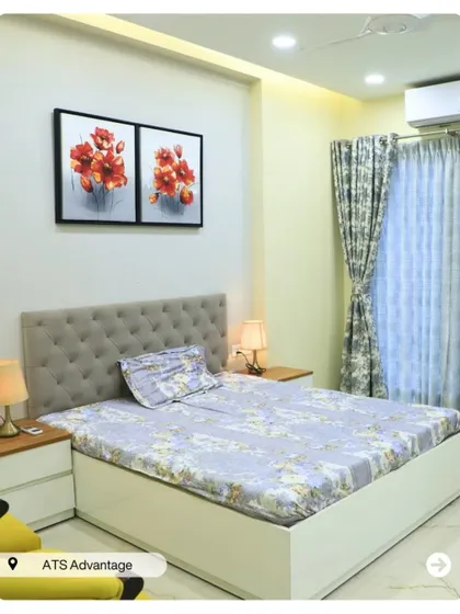A calm and soothing bedroom with a simple tufted headboard and floral artwork. The light wood nightstands and lamps create a balanced and peaceful environment.