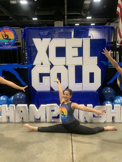 Our Xcel Gold athletes showing off their skills and flexibility even while posing for a photo at regionals!