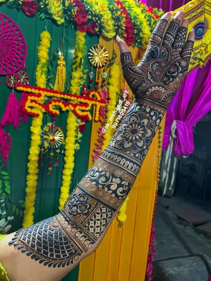 A single arm shot against the backdrop of a mehndi ceremony, showing how the intricate henna stands out.