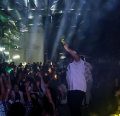 An MC hypes up the crowd on stage at the corporate party.