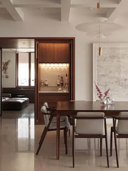 In this dining area, we used minimalist pendant lights to provide focused illumination without distracting from the overall space. The lighting works in concert with the concealed bar light to create layers of ambiance.