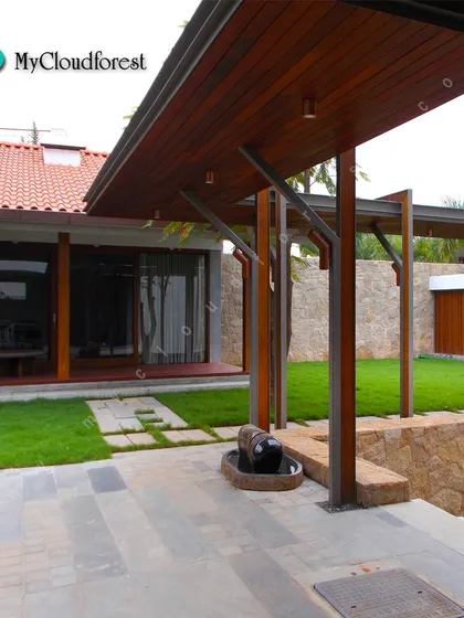 This design combines a neat lawn with modern hardscaping elements. A stone path leads from the patio to the garden, seamlessly connecting the home's indoor and outdoor living areas.