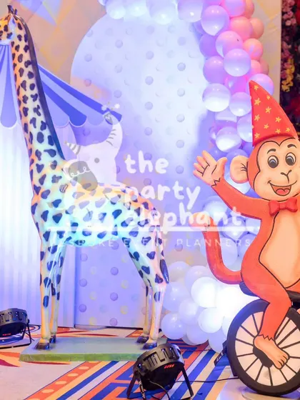 Even within a theme, there are variations. This pastel carnival setup uses a softer color palette, featuring a friendly giraffe and a monkey on a unicycle for a gentler, whimsical take on the circus theme.