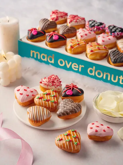 Another view of the assorted heart-shaped donuts, highlighting the packaging and the variety of toppings.