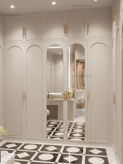 This elegant walk-in closet features arched wardrobe doors and a mirrored central panel, creating a classic and sophisticated look. The black and white geometric flooring adds a touch of modern contrast.