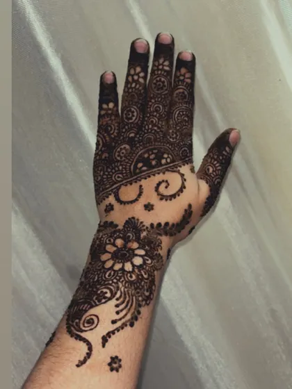 A clear view of the fresh henna paste for this floral and swirl design. Notice the neatness of the lines and the solid fill, which are key to a flawless final stain.