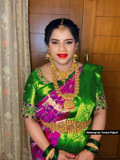 A full portrait of a stunning bride. Her makeup is perfectly balanced to complement the grandeur of her attire, creating a look of timeless South Indian elegance.