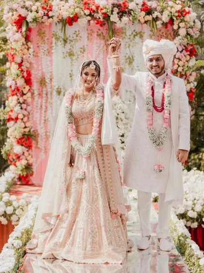 The victory pose. This is a classic wedding portrait that every couple wants, celebrating their union with hands raised high.