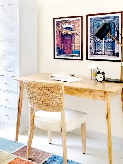 For the kids' room in the JWD Marq Home, I created this clean and minimal study area. The natural wood desk and rattan-back chair add charm and character, while the colorful rug and art keep the space feeling youthful and fun.