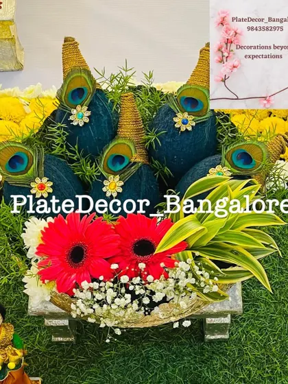 This is a traditional coconut decoration, where I use rich blue velvet, golden thread, and peacock feathers. This type of auspicious platter is perfect for poojas, weddings, and housewarming ceremonies.