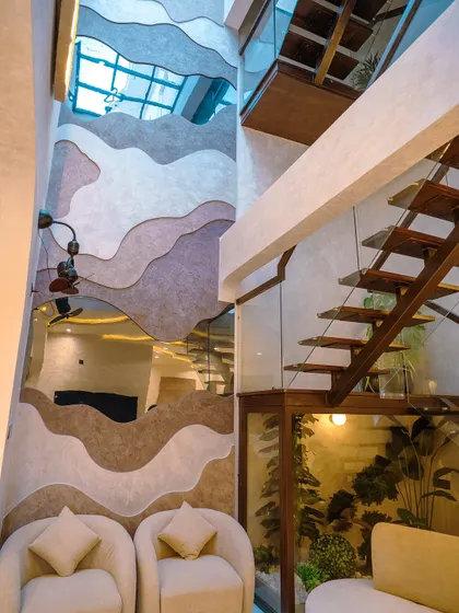 Another perspective of the contour wall, showing its connection to the floating staircase and the light from the skylight above.