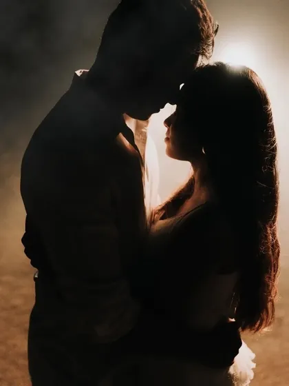 A silhouette of a couple embracing, with a warm, glowing light behind them. This shot is all about intimacy and mood.