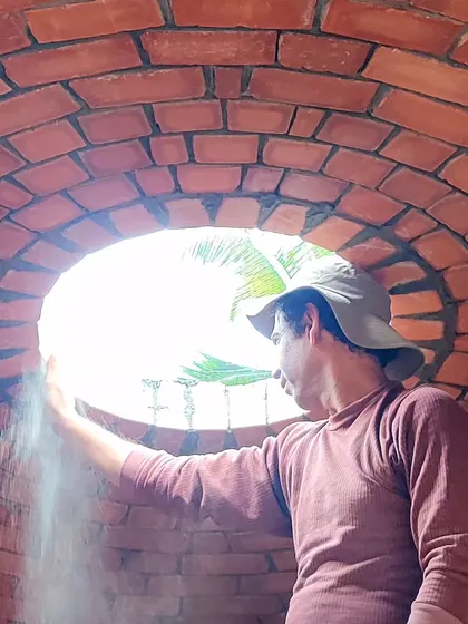 Inspecting the finished brick dome from below, through the oculus that will soon become a skylight.
