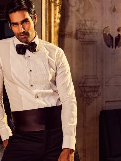 A portrait from the Camessi campaign, focusing on the details of the men's tuxedo shirt and bow tie.