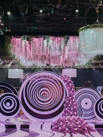 The entrance and photo-op area for the psychedelic Sangeet. Giant, hypnotic spiral discs and a cascade of purple flowers created a bold and immersive first impression for guests.