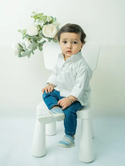 Sometimes, simplicity is the most beautiful. This classic milestone portrait uses a clean, white background to keep the focus entirely on your baby's natural expressions and curious personality.