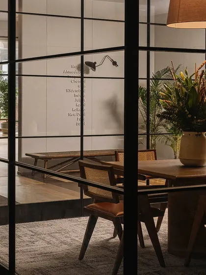 A teaser shot from behind the glass partition, hinting at the fully styled conference room. The play of reflections and transparency is a recurring theme in this project.