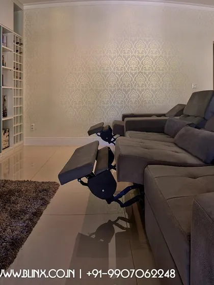 This living room setup features a large screen integrated into a custom media wall. The reclining sofa provides ultimate comfort, allowing the family to transition from a casual living area to an immersive movie watching environment with ease.