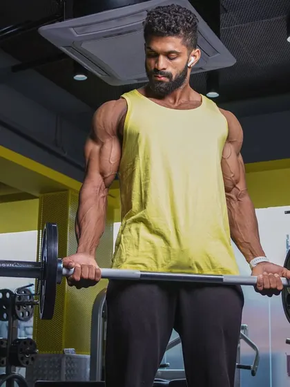 An EZ bar curl in progress. This exercise is excellent for targeting different parts of the bicep. My programs incorporate a variety of movements to ensure complete muscle development.