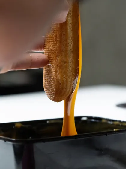 Dipping a delicate tuile into a rich caramel glaze. These are the moments of pure pastry artistry that happen every day in our masterclasses.